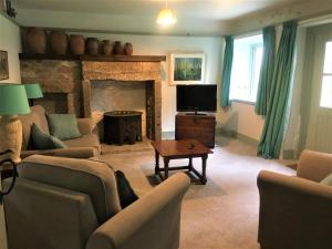 a living room with a fireplace and a tv at Doolans in Falmouth