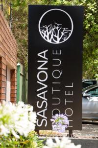 un cartello per un hotel con dei fiori davanti di Sasavona Boutique Hotel a Polokwane