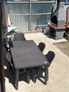 a black table and chairs with a pizza oven at Vila Dan in Galaţi