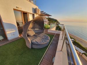 a chair sitting on a balcony next to the water at HPManagement Byala Beach Residence Apartments in Byala