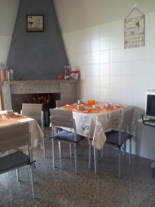 una sala da pranzo con tavoli, sedie e camino di B&B La Casa di Angelica a Roseto degli Abruzzi