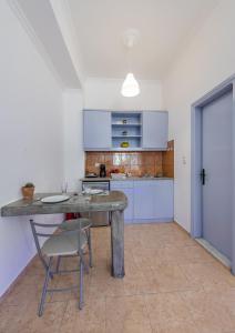 a kitchen with a table and a chair in a room at SantoriniNY in Perissa