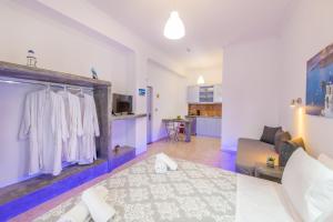 a living room with a couch and a kitchen at SantoriniNY in Perissa