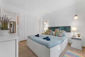 コスタ・テギセにあるThe Birds House Peaceful Garden Retreatの白いベッドルーム(青いシーツを使用した大型ベッド1台付) +24枚の写真