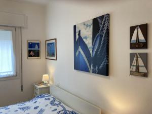 een slaapkamer met een bed en wat foto's aan de muur bij Romea in Rosolina Mare +34 foto's