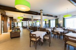 un restaurante con mesas y sillas blancas y ventanas en Sa Bassa Plana en Cala Pi