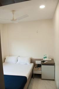 a small bedroom with a bed and a desk at City Hotel in Mumbai