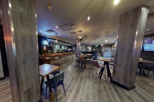 史云顿斯温顿乡村酒店的有桌椅和酒吧的餐厅
