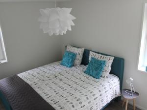 ein Schlafzimmer mit einem Bett mit blauen Kissen in der Unterkunft Bungalow near Veerse Meer with Private Garden in Kamperland