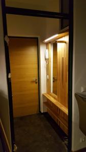 a bathroom with a wooden door and a sink at Haus Wieser in Lienz