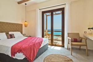 um quarto com uma cama e vista para o oceano em Ypsilos Beach Suites em Kyra Panagia