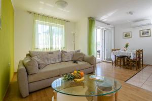 a living room with a couch and a glass table at Apartment Matej in Rabac