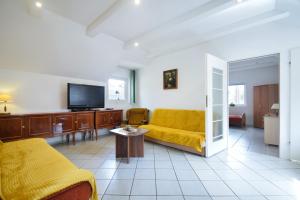 a living room with a yellow couch and a tv at Gryf Mare in Międzywodzie