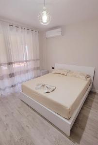 een witte slaapkamer met een bed in een kamer bij Small Studio near the Olimpik Park in Tirana