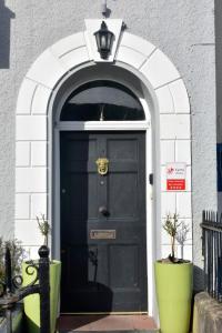 an archway with a black door with a lamp above it at Eaton house in Pembroke