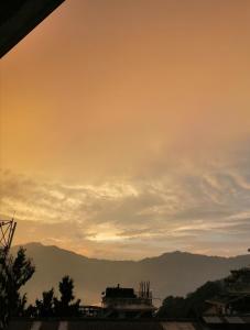 a view of a sunset with mountains in the background at Hotel Nindik in Gangtok