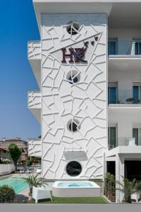 a white building with a sign on the side of it at Hotel Rondinella e Viola in Rimini