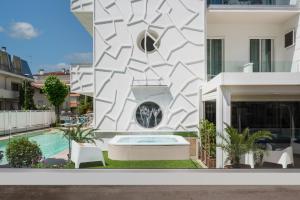 a facade of a building with a swimming pool at Hotel Rondinella e Viola in Rimini