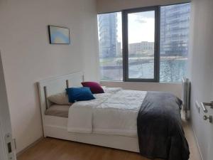 a bedroom with a bed with a large window at Amazing Apartment in a vibrant Area with Stunning Lake View in Istanbul! in Esenyurt