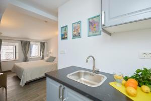 een keuken met een wastafel en een slaapkamer met een bed bij Room Annette in Dubrovnik