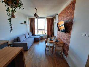 a living room with a blue couch and a brick wall at Nadmorski Bursztyn in Rowy