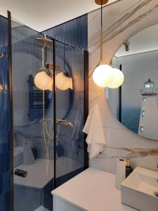 a bathroom with a shower and a sink and lights at Nadmorski Bursztyn in Rowy +115 photos