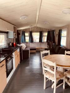 94 Newquay Bay Resort pet friendly في نيوكواي: مطبخ وغرفة طعام مع طاولة في القافلة