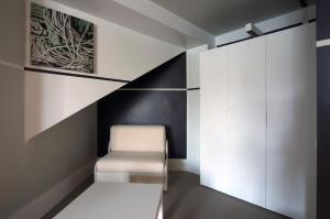 a room with a white chair and a cabinet at Hotel Piccolo Portofino in Portofino