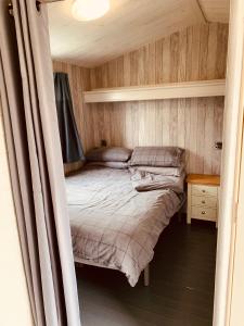 94 Newquay Bay Resort pet friendly في نيوكواي: غرفة نوم صغيرة مع سرير وطاولة