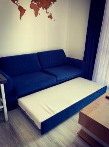 a blue couch with a white mattress in a room at RiverSea Apartment Saranda in Sarandë