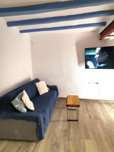 uma sala de estar com um sofá azul e uma televisão em Mediterrani Haus em L'Ametlla de Mar