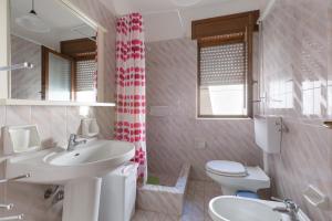 a white bathroom with a sink and a toilet at Case al Tacco di Leuca in Marina di Leuca