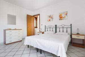 a white bedroom with a bed and a dresser at Case al Tacco di Leuca in Marina di Leuca