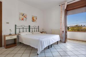 a bedroom with a bed and a large window at Case al Tacco di Leuca in Marina di Leuca