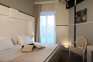 a bedroom with a bed with a chair and a window at Hotel Piccolo Portofino in Portofino