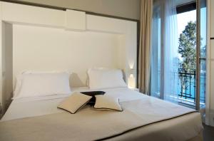a large white bed with two pillows and a window at Hotel Piccolo Portofino in Portofino