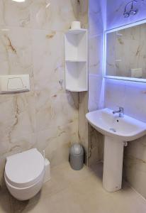 een badkamer met een wit toilet en een wastafel bij Small Studio near the Olimpik Park in Tirana