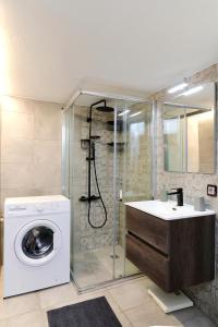 een badkamer met een wasmachine en een douche bij Venias Two-Bedroom apartment Kallimarmaro and Zappeio area in Athene
