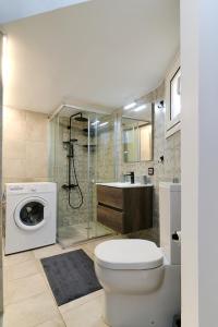 een badkamer met een toilet, een douche en een wasmachine bij Venias Two-Bedroom apartment Kallimarmaro and Zappeio area in Athene