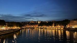 Blick auf einen Fluss mit einer Stadt in der Nacht in der Unterkunft Berges du Rhône/ Chambre avec balcon in Lyon