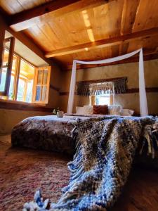 een groot bed in een kamer met een houten plafond bij Buddha House in Kasol