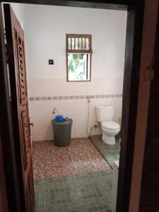 a bathroom with a toilet and a window at Enter Point in Bukit Lawang