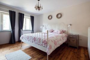 - une chambre avec un lit blanc et un lustre dans l'établissement Vakantiewoning Tivoli, à Dilsen-Stokkem
