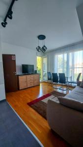 een woonkamer met een bank en een tafel en stoelen bij Apartments NEO in Novi Sad