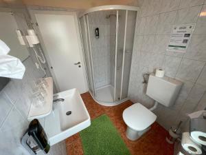 y baño con aseo, lavabo y ducha. en Pension Göschlberger, en Mondsee