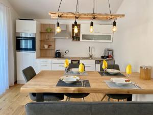 uma cozinha com uma mesa de jantar em madeira e cadeiras em Zirbenblick Apartment Turrach em Brandstätter