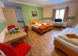 a hotel room with two beds and a table and chairs at Pension Göschlberger in Mondsee