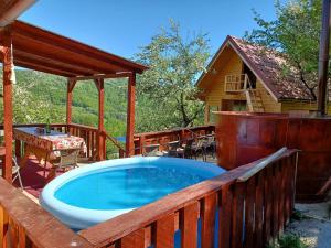 a hot tub on a deck next to a cabin at Relaxare in Sohodol, Alba in Sohodol
