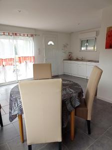 a dining room table with two chairs and a kitchen at Appartement de 2 chambres avec terrasse amenagee et wifi a Arnage in Arnage