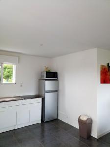 a kitchen with white cabinets and a microwave at Appartement de 2 chambres avec terrasse amenagee et wifi a Arnage in Arnage